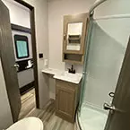 Bathroom with toilet with floor flush, sink with mirrored medicine cabinet, and shower with sliding glass door May Show Optional Features. Features and Options Subject to Change Without Notice.