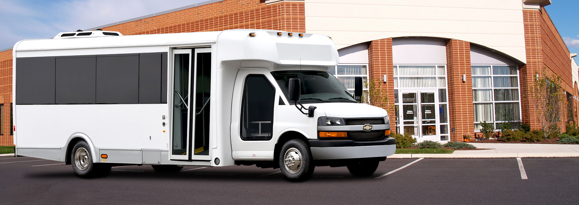 Shuttle bus in front of a brick building