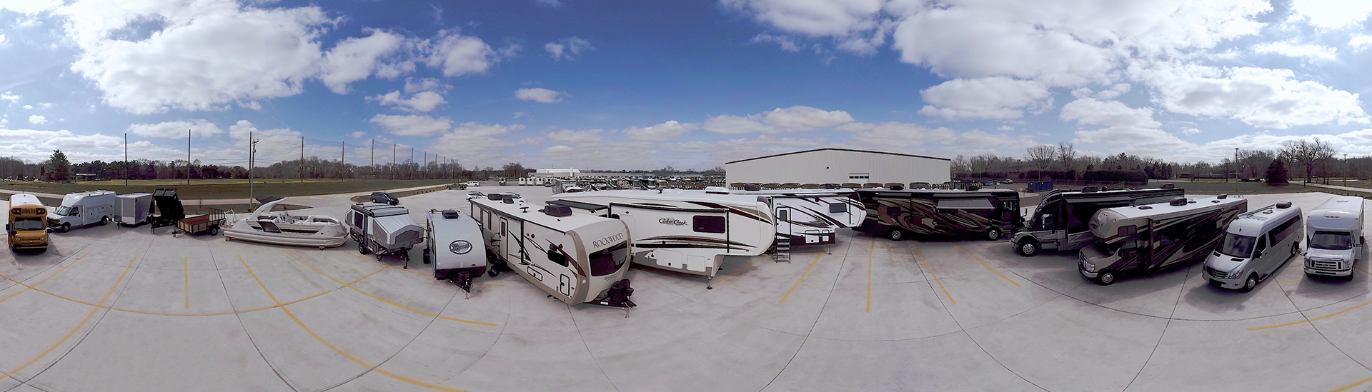 line up of shuttle buses, pontoon boats, cargo trailers and recreational vehicles